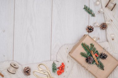 Noel hediyeleri, dekorasyonlar ve beyaz ahşap arka planda çam kozalakları. Üst görünüm