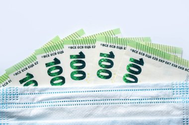 100 Euro 'luk banknotlarda tıbbi maske. Seçici odaklanma. 100 Avro Aşı Teşvik Konsepti. COVID-19 'a karşı aşı olma hediyesi.