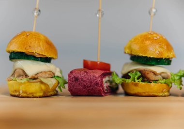 Aperatifler: Tahtada mini burgerler ve tortilla soslu sandviçler..