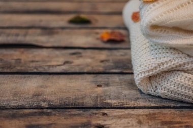 Sonbahar kompozisyonu. Beyaz kadınlar süveter giyer, sonbahar yaprakları eski moda ahşap arka planda. Düz konum, üst görünüm, kopyalama alanı