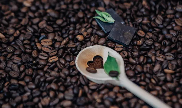 焙煎したコーヒー豆の食感の背景 コーヒー豆の上のグランドコーヒーの心の背景 — ストック写真