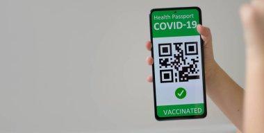 Aşılanmış çocuk ya da cep telefonlu dijital sağlık pasaportlu cep telefonu ile covid-19 salgını sırasında seyahat etmek. Yeşil sertifika, qr kodu