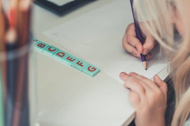 Eğitim konsepti - Küçük kız yazmayı, yazmayı öğreniyor. 