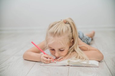 Renkli kalemlerle çizen tatlı bir kız. Evde eğitim ve eğitim kavramı.