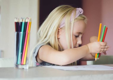 Renkli kalemlerle çizen tatlı bir kız. Evde eğitim ve eğitim kavramı.