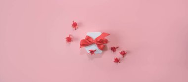 Pembe arkaplandaki hediye ve küçük çiçekler kopya alanı ile.