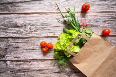 Tahta arka planda sebzeli kağıt torba manzarası. Sağlıklı yemek geçmişi. Alışveriş, online sipariş, pazarlama, gıda süpermarketi ve temiz vegan yeme konsepti..
