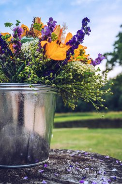 Kovada bir buket yabani yaz çiçeği. Çiçek teslimatı kavramı.