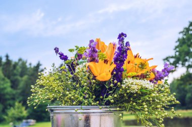 Kovada bir buket yabani yaz çiçeği. Çiçek teslimatı kavramı.
