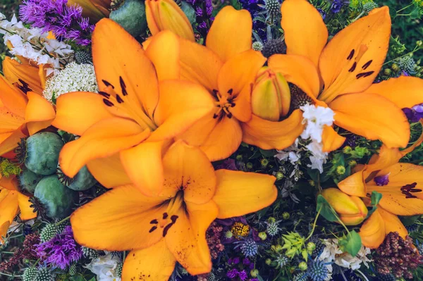 Turuncu zambaklar ve karışık yaz çiçekleri. Yaz çiçeği arka planı.