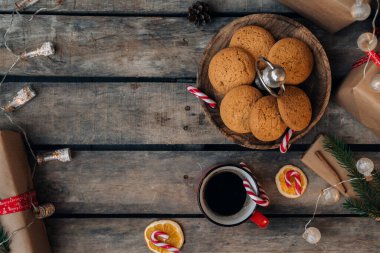 Noel tebrik kartı tasarımı. Bir sürü Noel hediyesi, çelenk, dekorasyon ve kırsal ahşap masada bir fincan kahve. Üst görünüm.