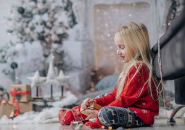 Mutlu Noeller ve mutlu tatiller! Noel 'den önceki sabah. Noel kazağı giyen mutlu bir kızın portresi.