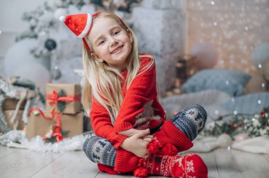 Noel şapkası ve kırmızı kazak giyen güzel sarışın kız. Noel tebrik kartı tasarımı