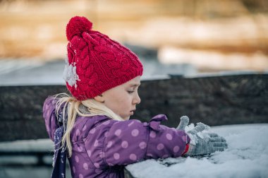 Mutlu küçük kız kışın dışarıda oynuyor. Kış etkinliği