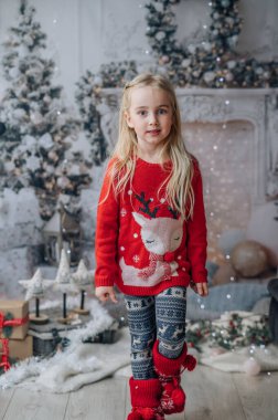 Mutlu Noeller ve mutlu tatiller! Noel 'den önceki sabah. Noel kazağı giyen mutlu bir kızın portresi.