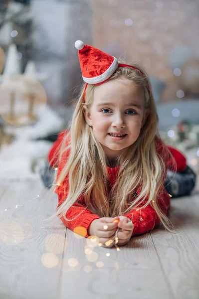 Hermosa Niña Sentada Suelo Una Sala Estar Usando Sombrero Santa — Foto de Stock