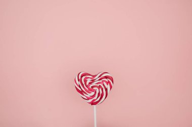 Pembe Sevgililer Günü kalp şeklinde lolipop şekeri boş pastel pembe kağıt arka planda. Aşk Konsepti. Üst Manzara. Minimalizm renkli hipster tarzı.