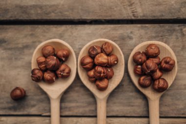 Tahta arka planda kaşık içinde fındık kabuğu, kapat.