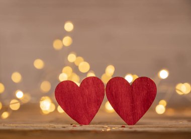Kırmızı kalp, Sevgililer Günü tebrik kartı. Bokeh geçmişi. Ahşap arka planda iki kalp ve bokeh ışıkları
