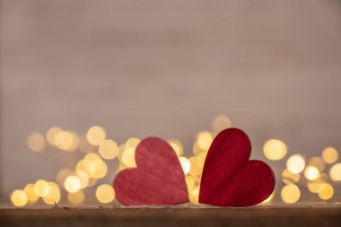 Kırmızı kalp, Sevgililer Günü tebrik kartı. Bokeh geçmişi. Ahşap arka planda iki kalp ve bokeh ışıkları