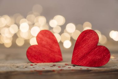 Kırmızı kalp, Sevgililer Günü tebrik kartı. Bokeh geçmişi. Ahşap arka planda iki kalp ve bokeh ışıkları