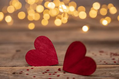 Kırmızı kalp, Sevgililer Günü tebrik kartı. Bokeh geçmişi. Ahşap arka planda iki kalp ve bokeh ışıkları