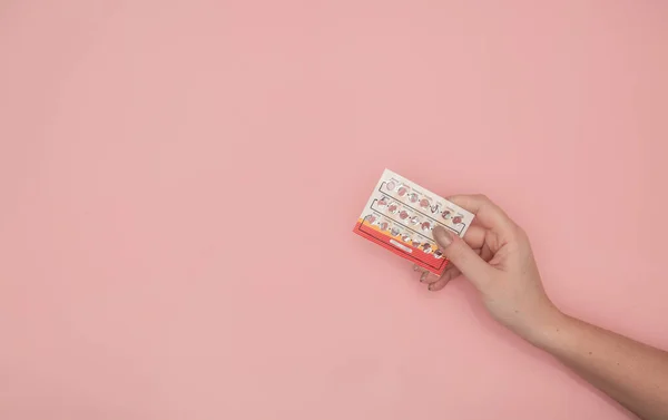 Mains Féminines Tenant Des Pilules Contraceptives Sur Fond Rose Les Photos De Stock Libres De Droits