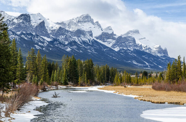 Rocky Mountains vie from the wooden bridge over the Spring Creek