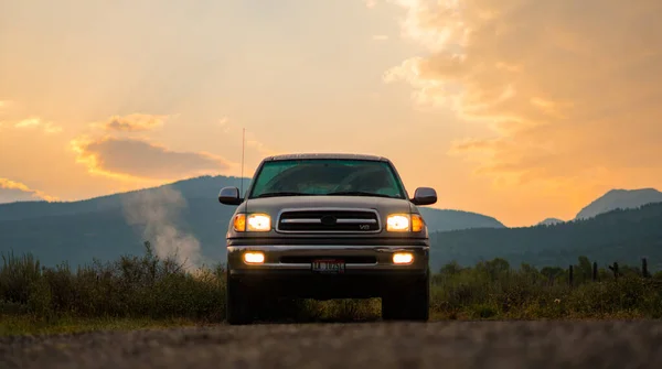 朝の陽気の中 山を背景に日の出の間にトラックが暖まる — ストック写真