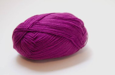 Beyaz arka planda renkli örgü iplikleri ve örgü iğneleri. İğne işi ve stres atımı