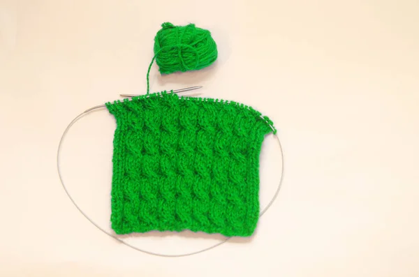 ピグテールのパターンを持つ手編みのキャンバス 白い背景にカラフルな編み糸と編み物の針のボール 針仕事とストレス解消 — ストック写真