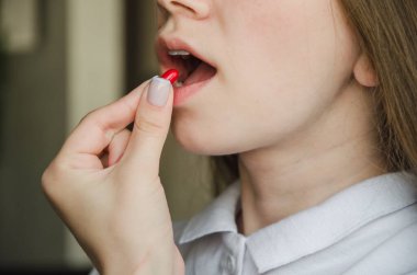 Kız ağzına beyaz hap koyuyor. tıp konsepti