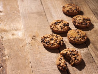 Kaba bir ahşap zemin üzerinde el yapımı çikolatalı kurabiyeler kırsal ahşap arka planda el yapımı çikolatalı kurabiyeler.