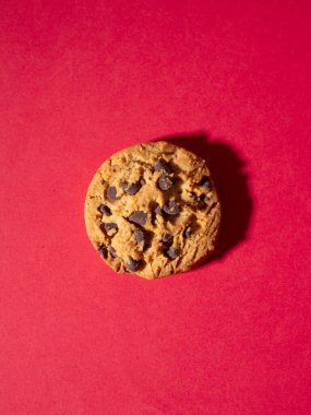 Kırmızı Noel arka planında ev yapımı çikolatalı kurabiyelerin en üst görüntüsü ahşap masada ev yapımı çikolatalı kurabiye.