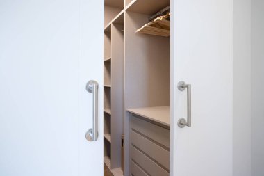 Giysiler olmadan dolap yarı açık.