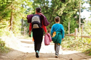 Tahta dağlarda yürüyen üç çocuklu bir anne. Aile seyahati ve çocuklarla yürüyüş..