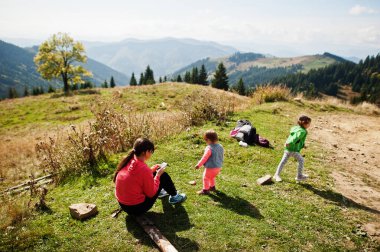 Anne ve kızları dağlarda eğleniyorlar. Aile seyahati, macera ve turizm kavramı. Yaşam tarzı ve sonbahar gezileri..