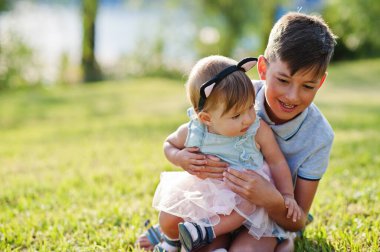 Türkiye 'de çimenlerde oturan erkek ve kız kardeş palmiyelere karşı tatil yapıyor.