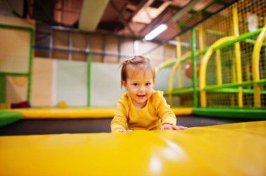 İçerideki oyun merkezinde trambolinde zıplayan tatlı bir kız bebek..