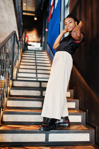 Kafede siyah bluzlu genç Afrikalı bir kadın var.. 