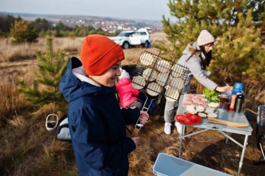 Çam ormanında bir güvertede aile barbeküsü. Izgarayla barbekü günü.