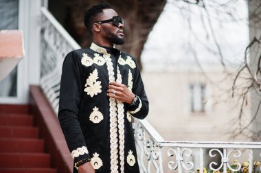 Geleneksel ceket giymiş mega stil Afrikalı bir adam. Güneş gözlüklü şık siyahi adam..