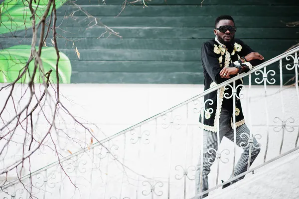 伝統的なジャケットのポーズでメガスタイリッシュなアフリカの男 サングラスのファッショナブルな黒男 — ストック写真