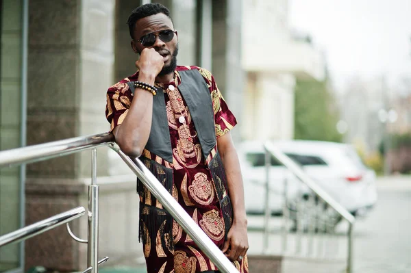 アフリカのスタイリッシュでハンサムな男で伝統的な衣装とサングラスは屋外に立って — ストック写真