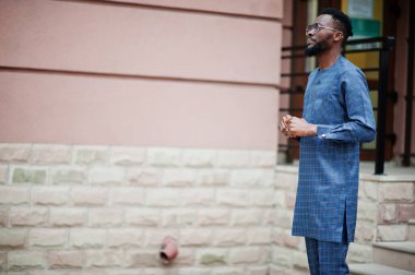 Mavi otantik kostümlü, gözlüklü Afrikalı adam. Moda Nijeryalı Adam.