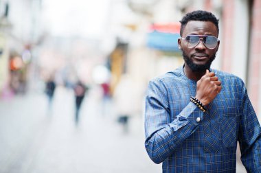Mavi otantik kostümlü, gözlüklü Afrikalı adam. Moda Nijeryalı Adam.