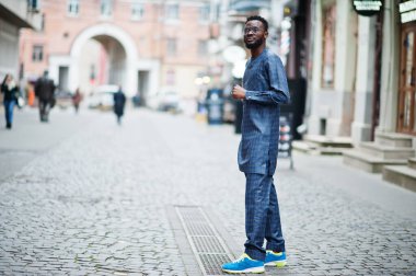 Mavi otantik kostümlü, gözlüklü Afrikalı adam. Moda Nijeryalı Adam.
