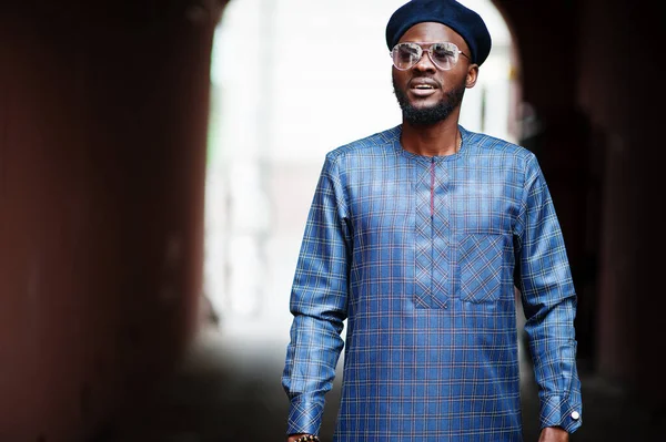 Mavi otantik kostümlü, gözlüklü ve bereli Afrikalı adam. Moda Nijeryalı Adam.