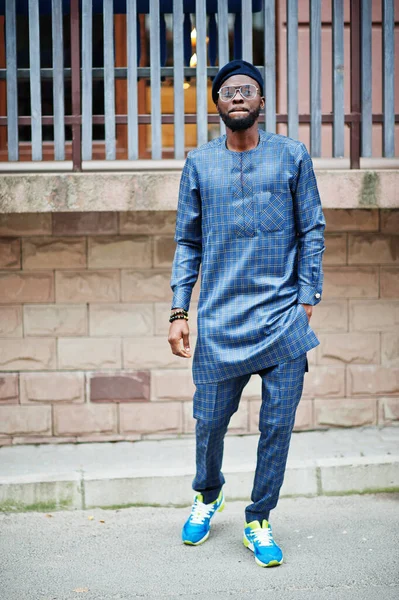 Mavi otantik kostümlü, gözlüklü ve bereli Afrikalı adam. Moda Nijeryalı Adam.