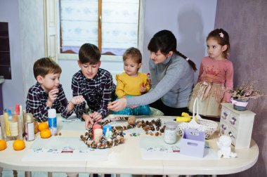 Dört çocuklu anne Noel arifesi için çelenk ve süsleme yapıyor. Yeni yıl kutlaması.